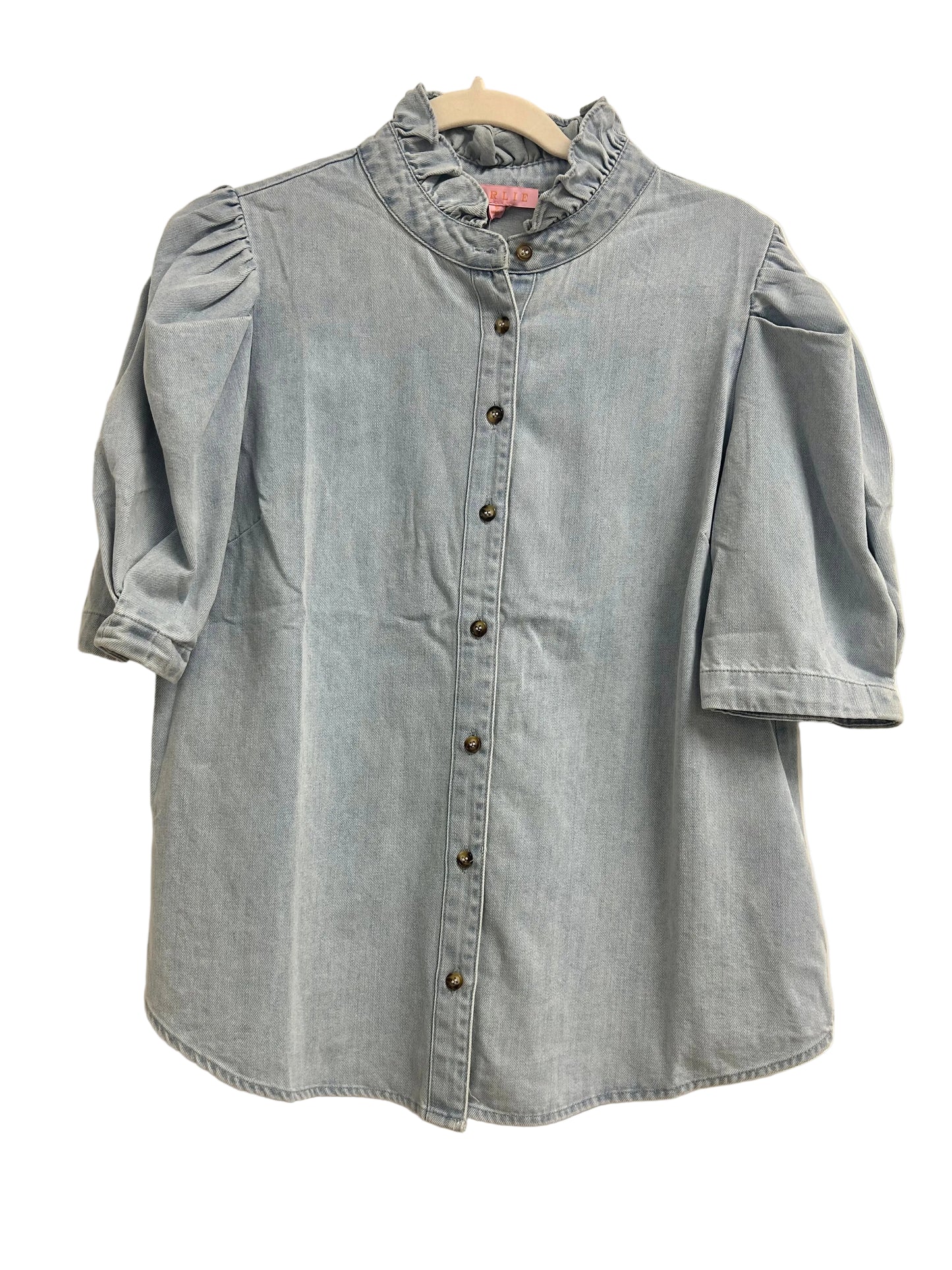 Light blue denim shirt on a hanger against a white door background