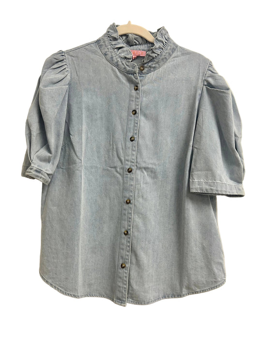 Light blue denim shirt on a hanger against a white door background